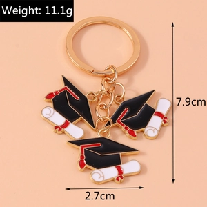Close-up of graduation keychain with black mortarboard and certificate charms
