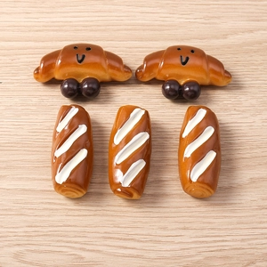 Gedetailleerd beeld van realistische hars bedeltjes in de vorm van brood en croissants