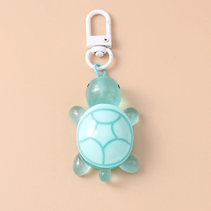 Detail view of a translucent mint green turtle keychain with silver glitter pattern