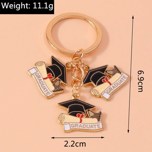 Detail view of golden graduation keychain showing dimensions and Graduate enamel charms