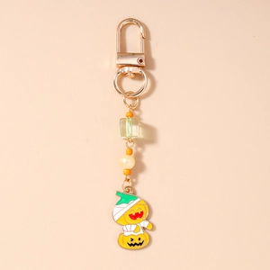 Detail of Halloween pumpkin mummy pendant with colorful beads on a gold keychain