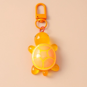 Close-up of a vibrant orange resin turtle keychain with a matching metal lobster clasp