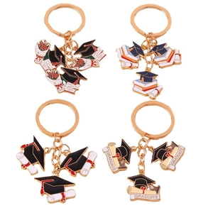 Gold graduation keychain set with doctorate cap, diploma scroll and books on white base