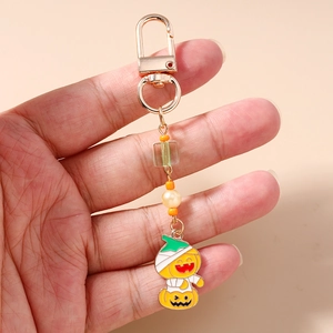 Detail of Halloween pumpkin mummy keychain with orange beads and golden clasp