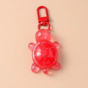 Detail view of a red translucent turtle charm with matching metal spring clasp hook