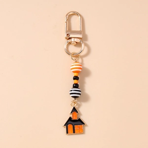 Detail of Halloween beaded keychain featuring orange striped beads and enamel house pendant