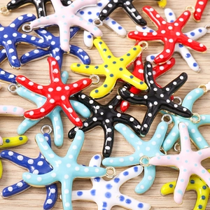 Macro-opname van kleurrijke emaille zeesterbedeltjes met stippen voor DIY-sieraden maken