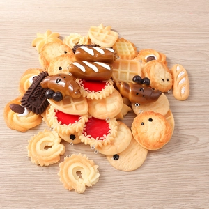 Macro shot of miniature dessert charms including waffles and croissants for DIY jewelry making