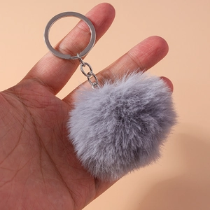 Detailed macro view of an 8cm gray faux fur pompom keychain with a silver metal ring