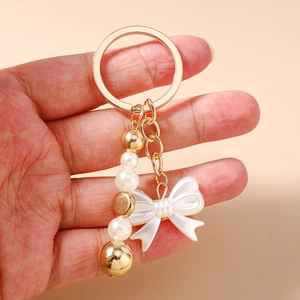 Porte-clés à la mode avec perles, nœud blanc et breloque étoile de mer dorée