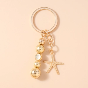 Détail d'un porte-clés doré avec perles solides et pendentif étoile de mer pour décoration