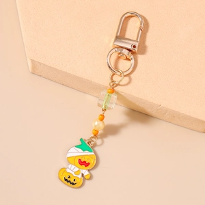 Detail of Halloween pumpkin mummy keychain with orange beads and gold lobster clasp
