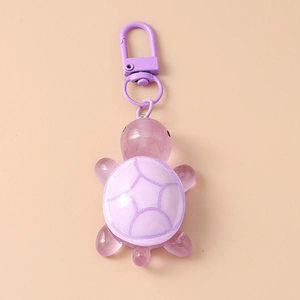 Detail showing translucent purple resin turtle keychain with color-matched metal clasp