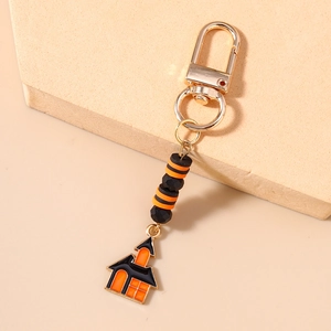 Detail of Halloween beaded keychain featuring orange-black stripes and house charm