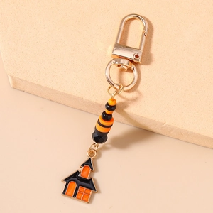 Close-up of Halloween beaded keychain with orange-black stripes and haunted house charm