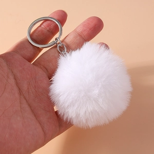 Detailed view of an 8cm white fluffy faux fur pompom keychain with a silver metal ring