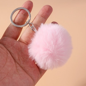Macro detail of a soft pink faux fur 8cm pompom keychain with a silver metal ring