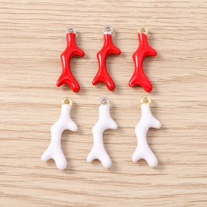 Detail van rode en witte koraaltak bedeltjes met metalen lussen voor DIY-sieraden