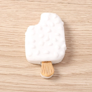 Detalle de dije de helado de resina con textura de chocolate blanco y palo realista