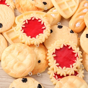 Macro detail of miniature resin food charms including waffles and cookies with metal loops