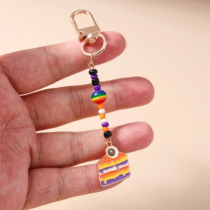 Detailed view of a rainbow beaded cake keychain with a gold D-ring and colorful charms