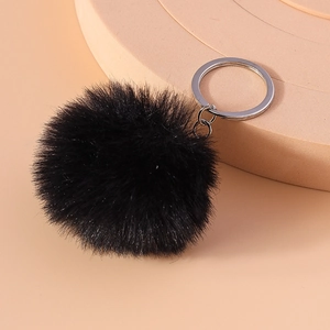 Detailed view of 8cm fluffy black faux fur pompom keychain with silver metal clip