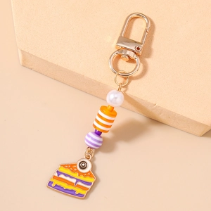 Detailed view of Halloween eyeball cake keychain with orange beads and golden clasp