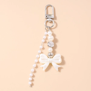 Detail view of y2k pearl bow keychain with silver lobster clasp and metallic accents