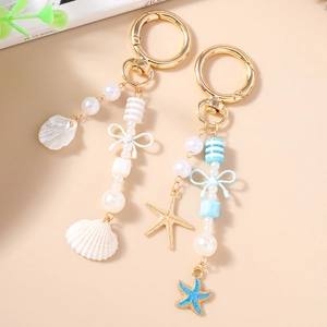 Mode oceaan thema sleutelhanger met witte parels, gestreepte kralen en gouden zeesterren