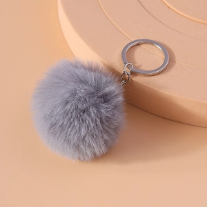 Detailed view of an 8cm grey faux fur pom pom keychain with a silver metal ring
