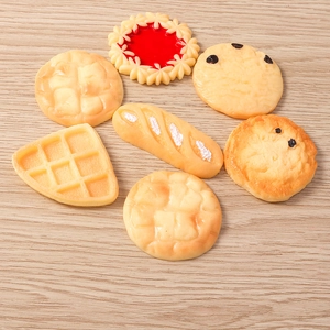 Realistische mini-voedselbedels van hars met wafels en koekjes op houten achtergrond