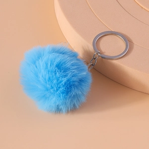 Detail of 8cm fluffy blue faux fur keychain with silver metal ring on pink background