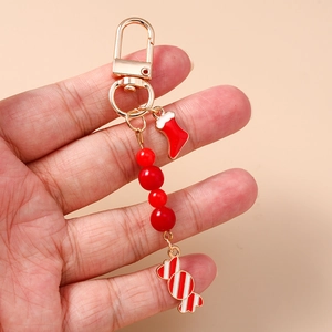 Porte-clés de Noël perlé avec chaussette et bonbon, tenu à la main pour l'échelle