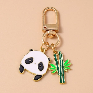 Détail du pendentif panda en émail et du charme bambou vert sur porte-clés doré