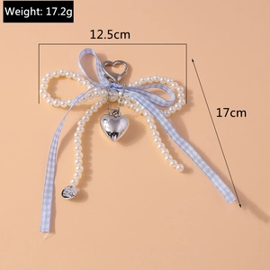 Détail du porte-clés en perles avec nœud en vichy bleu, pendentif cœur et fermoir en métal