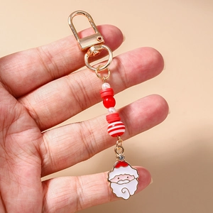 Close-up of a festive Christmas keychain featuring red and white beads and Santa Claus pendant