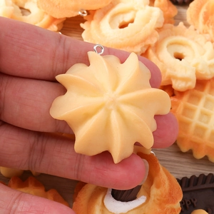 Macro detail of miniature resin cookie pendants with lifelike texture and metal loops