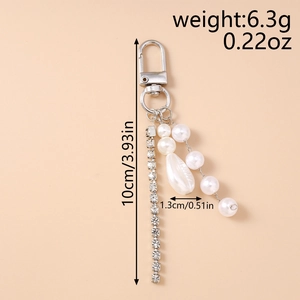 Macro view of crystal chain and teardrop pearl pendant on a silver keychain