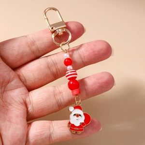 Detail of beaded Christmas keychain with Santa Claus charm held in person's hand