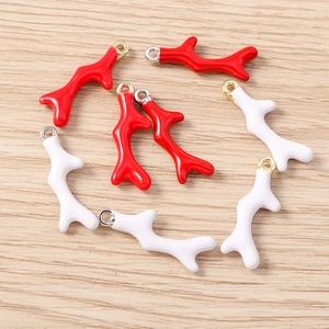 Gedetailleerde weergave van DIY koraaltak hangers in rood en wit email met metalen ringen