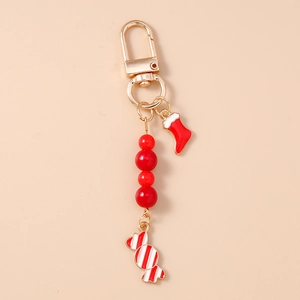 Détail du porte-clés de Noël avec perles rouges, chaussette de Père Noël et pendentif sucette