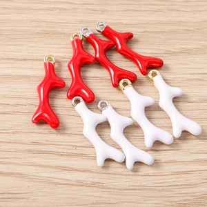 Detail van rode en witte koraal hangers met goudlaag voor doe-het-zelf sieraden