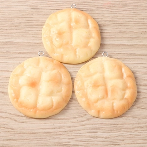 Detailed view of three realistic melon pan resin charms with textured gold finish for DIY crafts