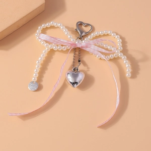 Détail du porte-clés nœud en perles avec ruban rose et pendentif en forme de cœur