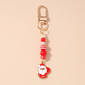 Detail of Santa Claus enamel charm with red and white striped beads on gold keychain