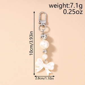 Détail du porte-clés en perles avec nœud blanc et dimensions de 10cm x 2,8cm