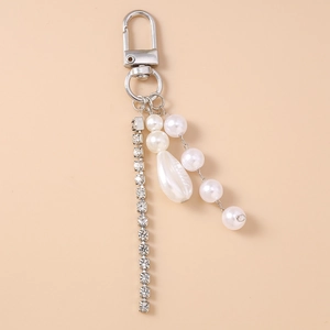 Detail of rhinestone chain and faux pearl pendant with lobster clasp for bag accessory