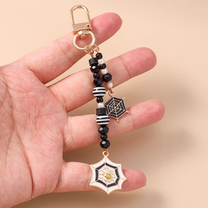 Detail view of Halloween beaded keychain with spider web pendant and golden clasps