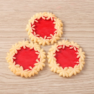 Macro detail of three realistic strawberry jam biscuit charms with silver metal rings