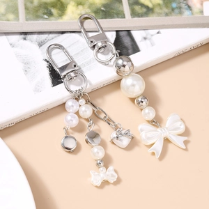 Porte-clés chic avec perles et nœuds élégants posé sur un fond de magazine de mode